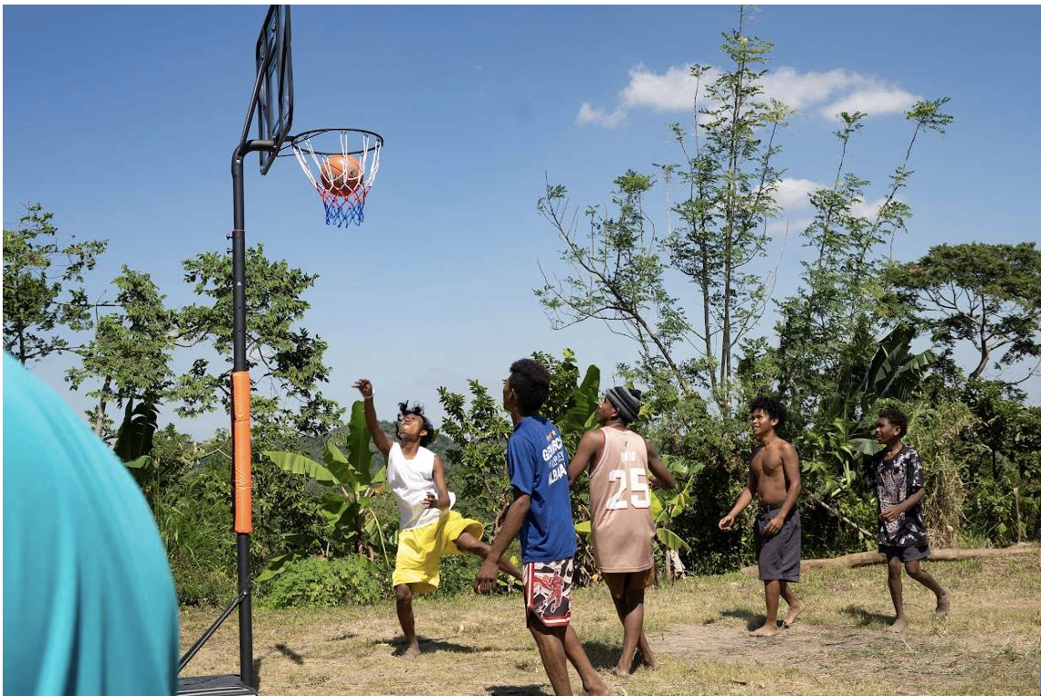 Young people playing basketball with the new hoop